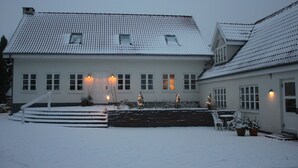 A two-story house with a snow-covered roof and steps leading to the front door. - Spangsgaard bed and breakfast (Odense)
