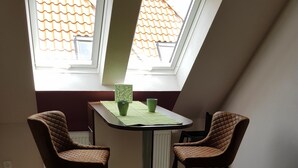 Un'angolare zona pranzo con un tavolo e quattro sedie, un termosifone e un lucernario.