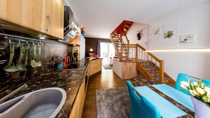 A modern kitchen with a marble countertop, wooden cabinets, and a built-in sink.