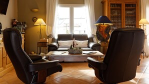 A living room with a sofa, two armchairs, a coffee table, and a cabinet with glassware. - Villa des Cammaous (Vacquieres)