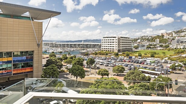 Une vue d’une marina avec des bateaux, un parking et des bâtiments en arrière-plan.