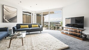Un salon moderne avec un canapé, une table basse et un téléviseur.