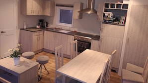 Una cocina moderna con armarios de madera, horno empotrado y ventana.