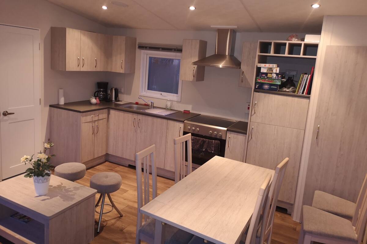 Una cocina moderna con armarios de madera, horno empotrado y ventana.