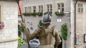 A statue of a knight holding a spear in a town square.
