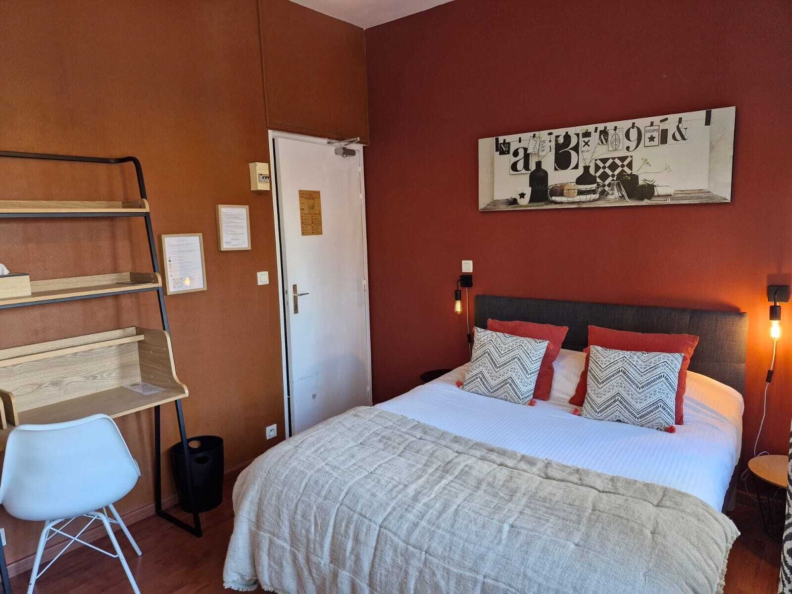 Ein Schlafzimmer mit einem Bett, einem Schreibtisch, einem Stuhl und einer Tür.