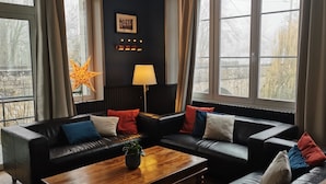 Un salon moderne avec un canapé en cuir noir, une table basse en bois et une décoration en forme d’étoile.