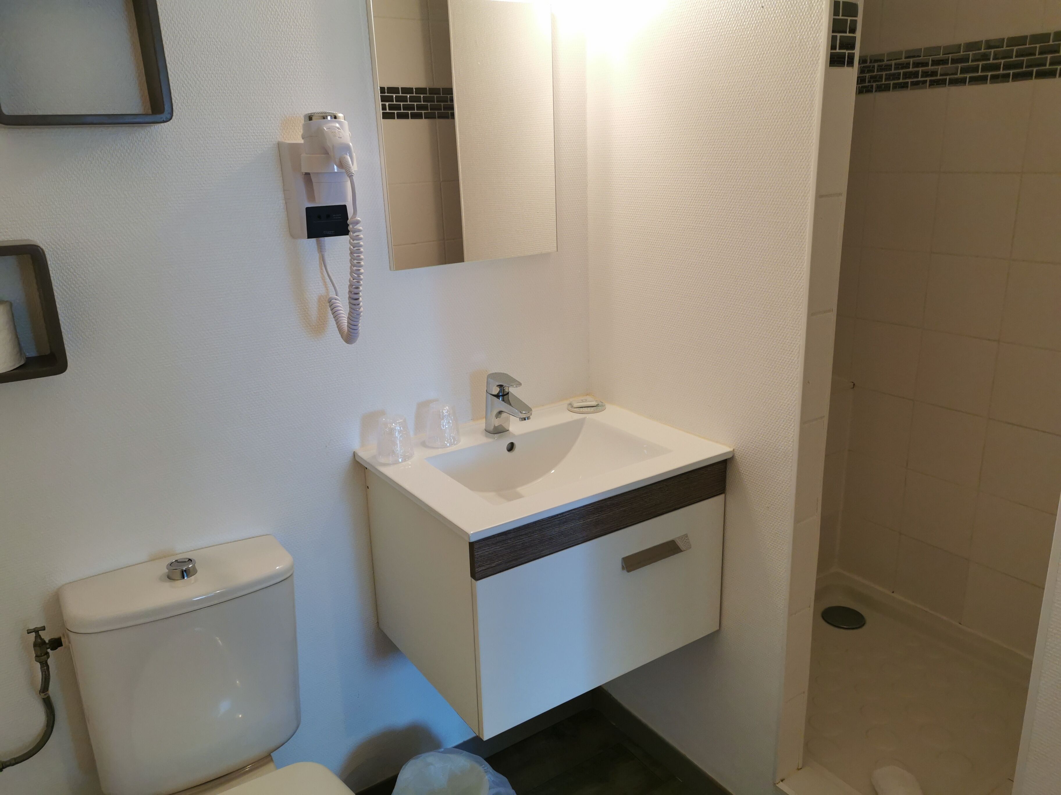 Un baño con inodoro, lavabo y ducha.