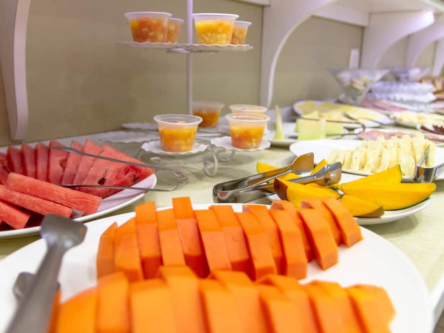 A buffet with various food items including watermelon, mango, and cheese.