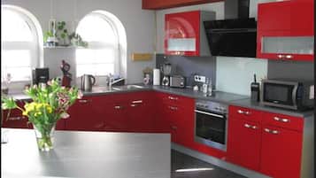 Lemari es di ruangan bersama, microwave, oven, dan kompor