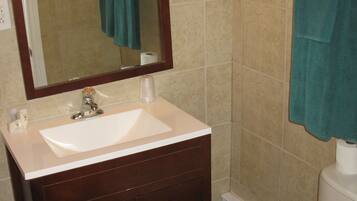 A bathroom with a white sink, dark wooden vanity, a mirror, a toilet, and two towels hanging on towel racks.