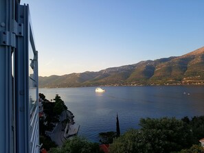 A view of a lake with a cruise ship and mountains in the background. - Apartments Ivancevic (Korcula)