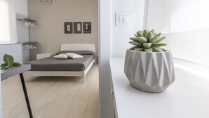 Camera da letto moderna con un letto, un comodino e una succulenta in vaso.