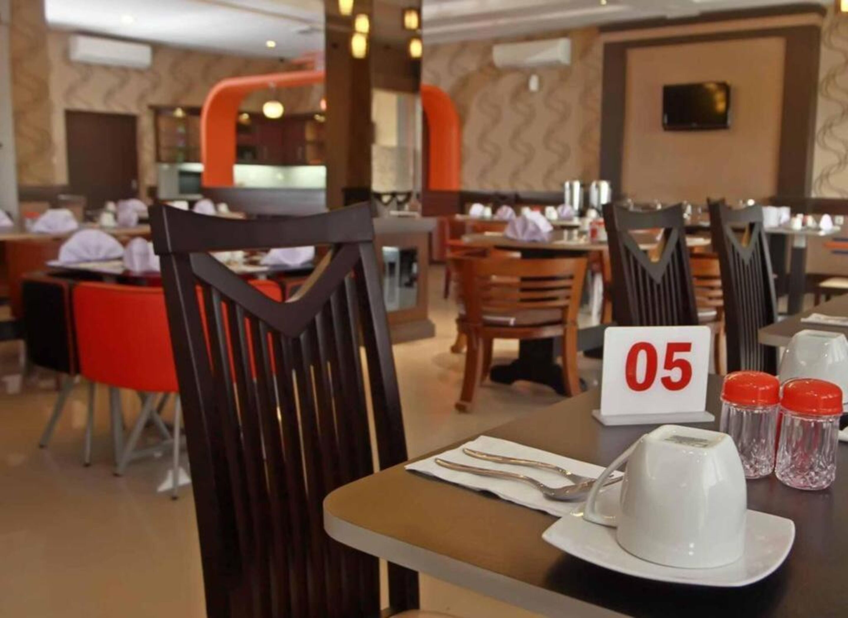 A restaurant interior with wooden chairs, tables, and a number sign indicating table 05.