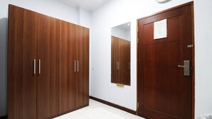 A room with a large wardrobe, a door, and a mirror. - Wisma Konservasi (Jakarta)