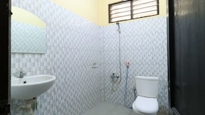 A bathroom with a sink, toilet, and shower. - Wisma Flamboyan (Surabaya)
