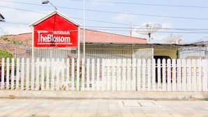 A fenced area with a red sign that reads "The Blossom." - Wisma TheBlossom (Padang)