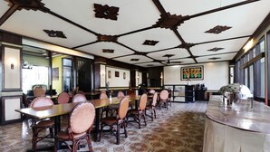 A conference room with a long table, multiple chairs, patterned floor tiles, and a decorative ceiling. - Hotel Istana Bandung (Bandung)
