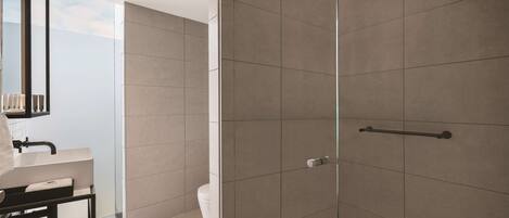 Une salle de bain moderne avec une douche à parois de verre, un lavabo blanc et un porte-serviettes.