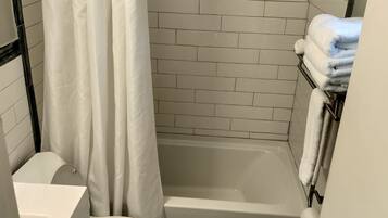 Un baño pequeño y funcional con inodoro blanco, bañera y cortina de ducha.