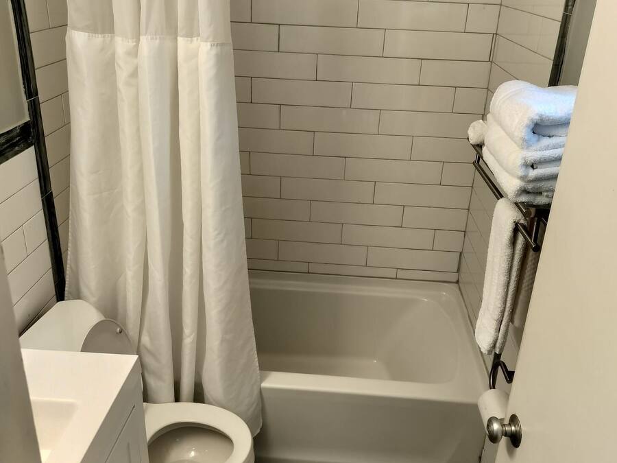 Un baño pequeño y funcional con inodoro blanco, bañera y cortina de ducha.