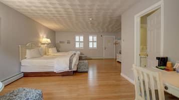 Un dormitorio con cama, mesita de noche, lámpara y escritorio con silla.