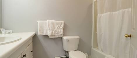 A bathroom with a toilet, sink, and bathtub.
