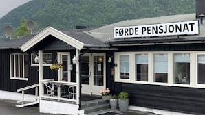 A black and white building with a sign reading "Førde Pensionat". - Førde Pensjonat (Sunnfjord)