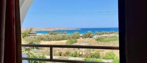 Un balcón con vista al mar y una pequeña mesa.