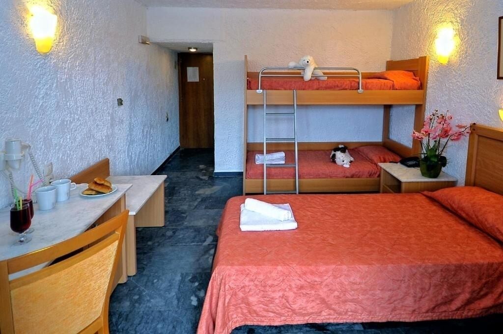 Una habitación con literas, un escritorio y una silla.