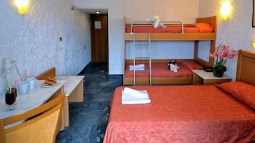 Een kamer met stapelbedden, een bureau en een stoel.