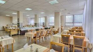 A spacious dining hall with multiple tables and chairs, a service counter, and large windows with sheer curtains. - Ensana Spa Smrdaky (Smrdáky)