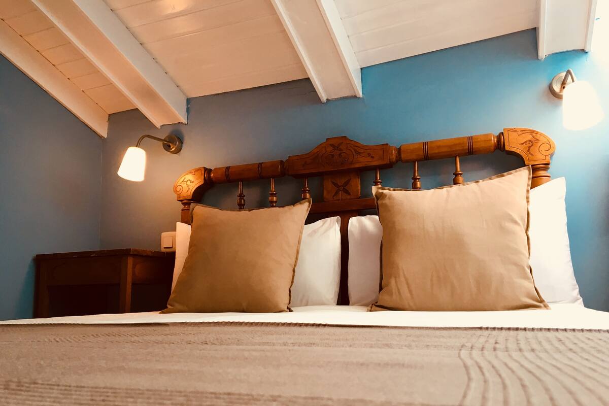 A bed with a wooden headboard, two pillows, and a nightstand.