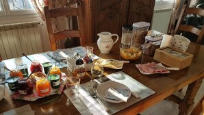 Une table à manger dressée avec différents plats, couverts et condiments.