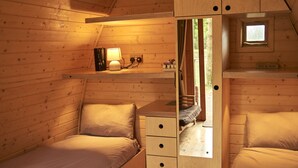 Una habitación acogedora estilo cabaña con dos camas, un escritorio pequeño y una ventana.