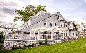 A large house with a covered porch and multiple umbrellas. - Friendly City Inn Bed & Breakfast (Harrisonburg)