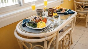 Ein Esstisch mit Frühstücksgebäck, zwei Orangensaftgläsern und einer Tasse.