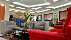 A modern living room with a sofa, armchairs, and a coffee table. - The Cape Hotel (Monrovia)