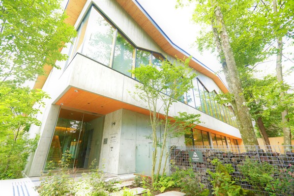 A modern building with large windows and a curved facade. - Regina Resort Kyukaruizawa (Karuizawa)