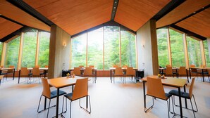 A spacious dining area with large windows, wooden tables, and chairs. - Regina Resort Kyukaruizawa (Karuizawa)