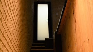 A staircase with wooden steps and a brick wall on one side. - Le Toit de Dinant - Esc’Appart (Dinant)