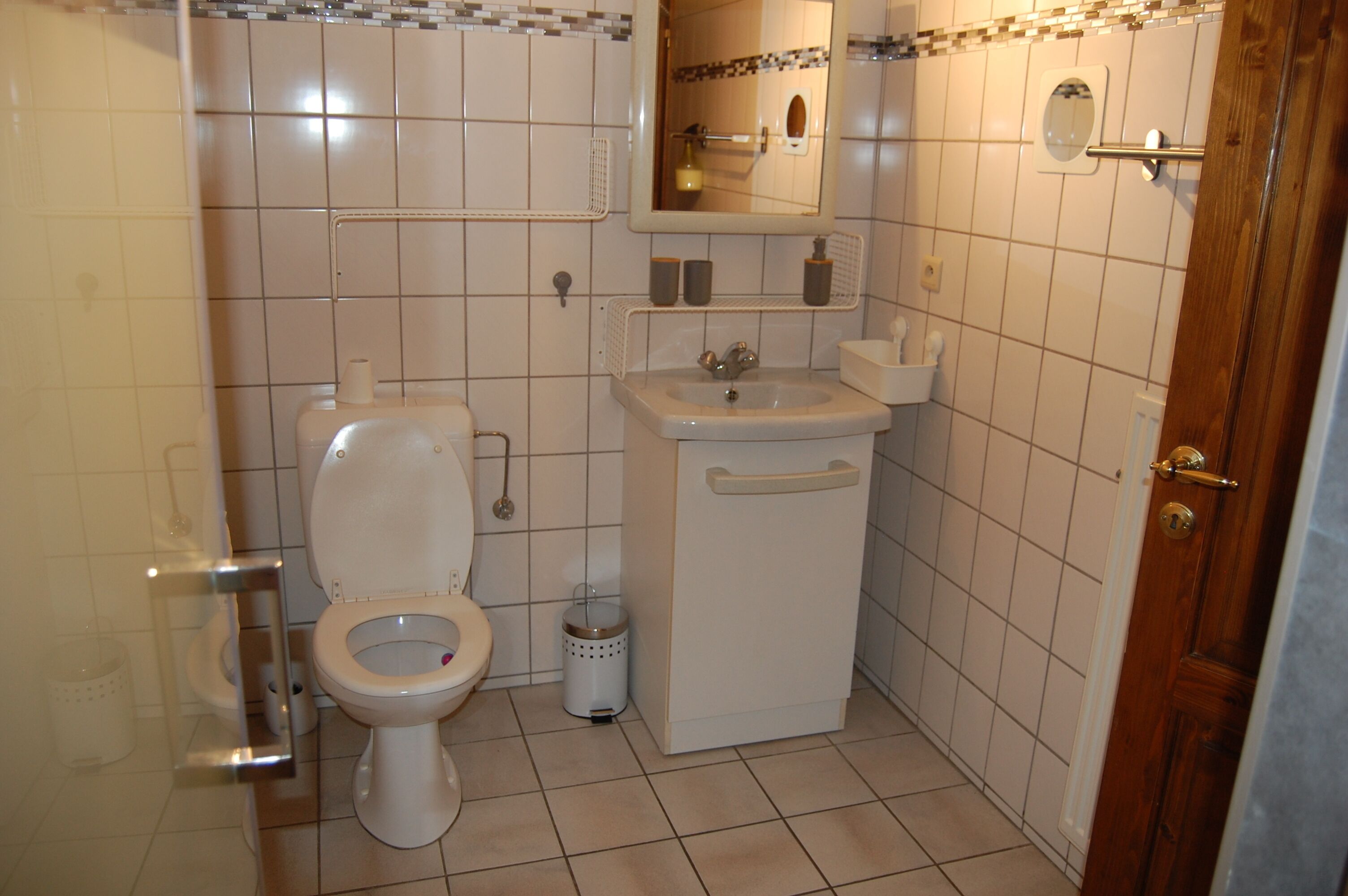 Un baño pequeño con inodoro, lavabo y espejo.