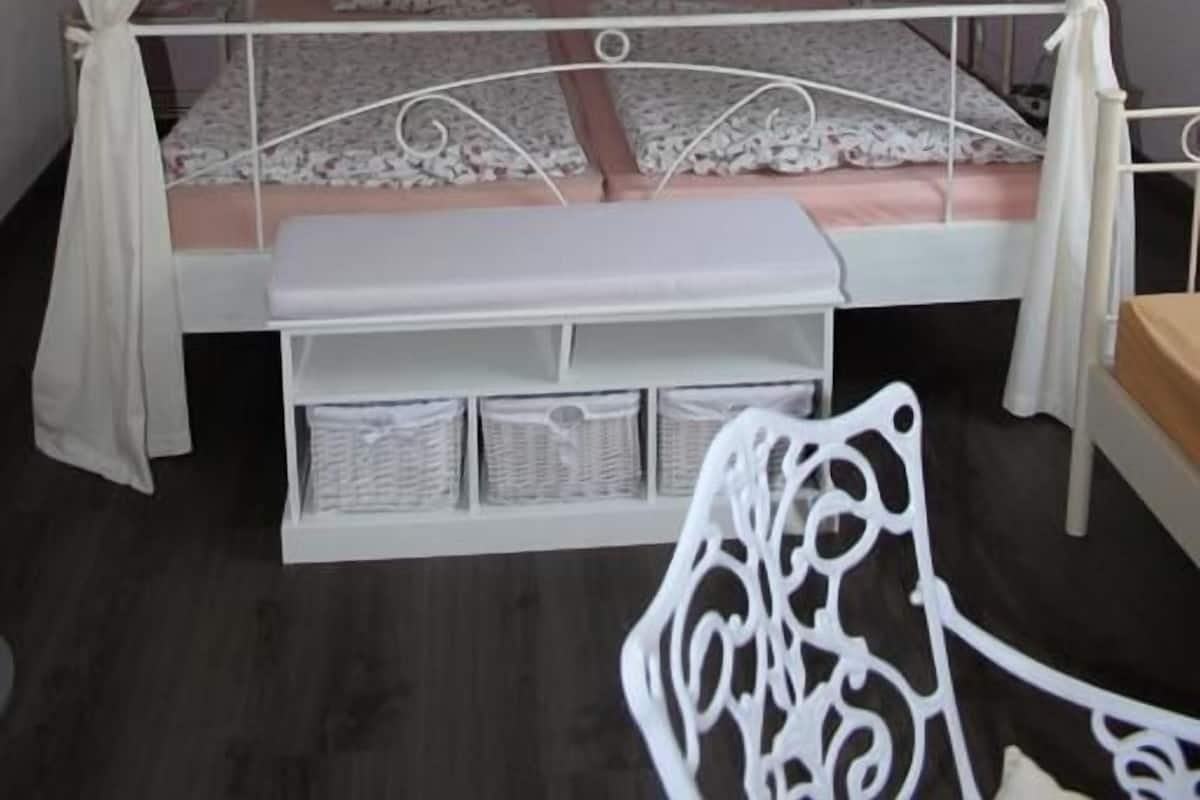 Un lit simple avec un baldaquin, une table de chevet et une chaise.