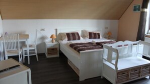 A single bedroom with a wooden ceiling, a bed with white bedding and patterned pillows, a bedside table with a lamp, and a chair. - Hotel Krone Kappel (Kappel-Grafenhausen)