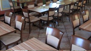 A restaurant with multiple tables and chairs, a bar area, and a large pillar. - Hotel Krone Kappel (Kappel-Grafenhausen)