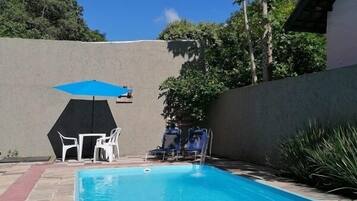 Alberca al aire libre, sombrillas en la alberca y camastros