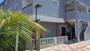 A multi-story building with balconies, a staircase, and a palm tree in the foreground. - Pousada Top (Mairipora)