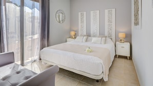 Une chambre bien rangée, avec un lit, des tables de chevet et une chaise.