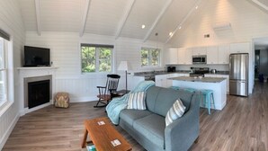 A spacious living room with a grey sofa, a wooden coffee table, and a fireplace. - New Listing - Island View Cottage (Phippsburg)