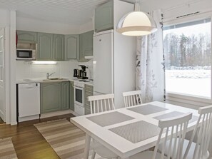 A compact kitchen with a microwave, coffee maker, and a dining area with a table and chairs.